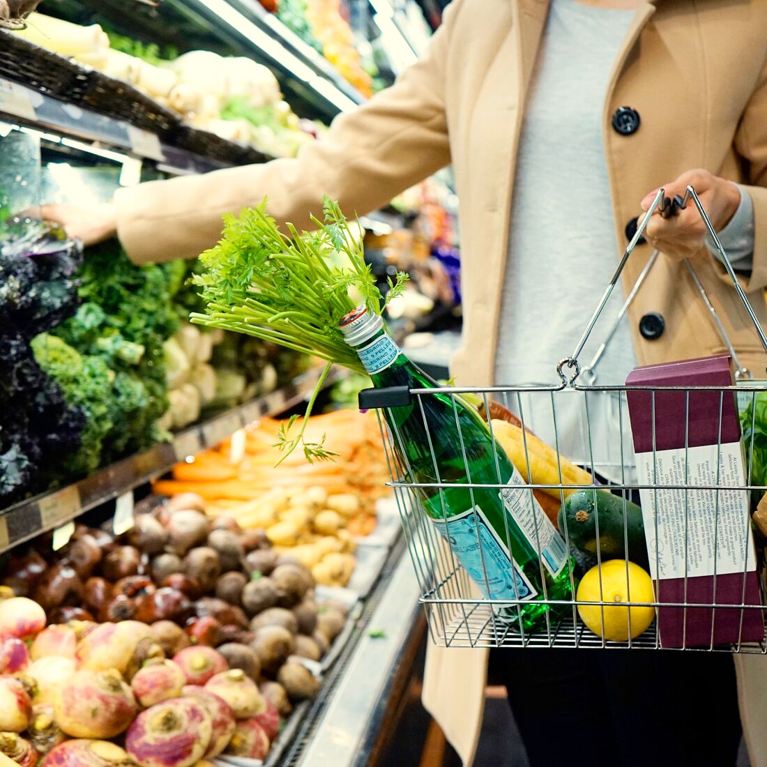 A shopper choosing vegetables in the produce department